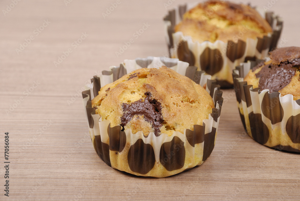 Homemade cupcakes with chocolate on a wooden table
