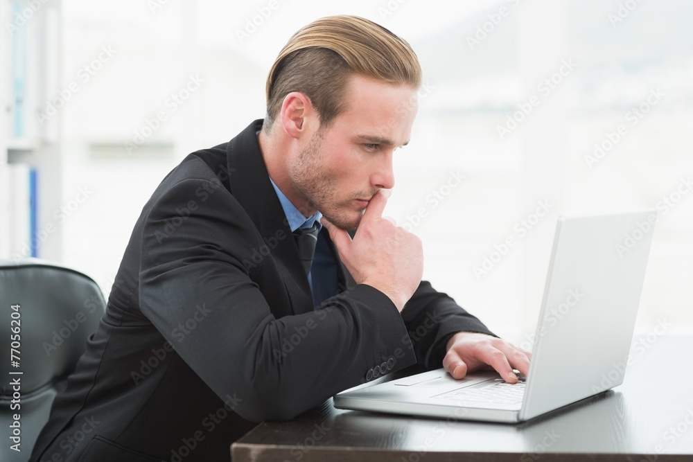 Focused businessman in suit using laptop Focused businessman in suit using laptop