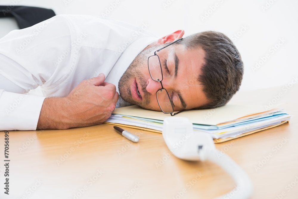 Exhausted businessman sleeping at his desk Exhausted businessman sleeping at his desk