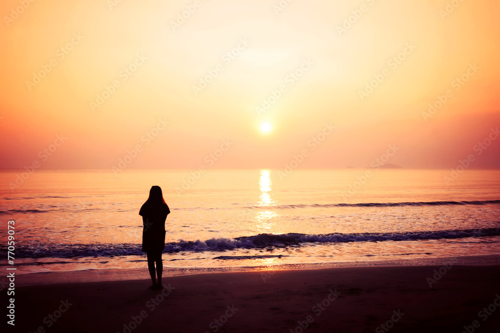 silhouette of woman alone and wave on the beach