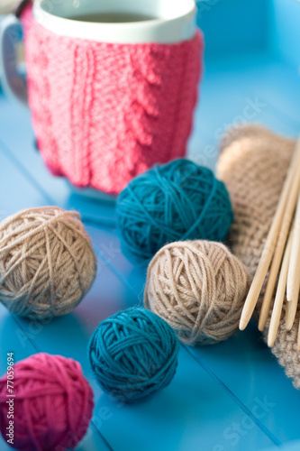 Bright balls of yarn, wooden knitting needles, knitted blanket l