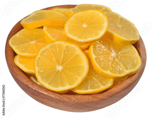 Lemon slices in a wooden bowl on a white