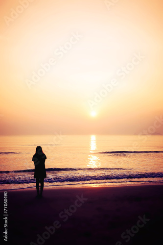 silhouette of woman alone and wave on the beach