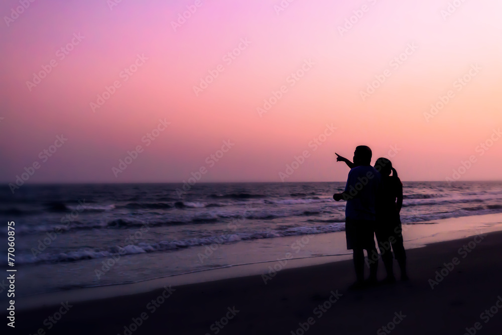 silhouette of couples hugging on the beach