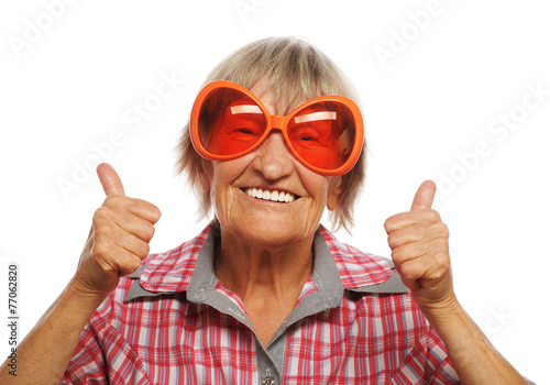 Senior woman wearing big sunglasses doing funky action
