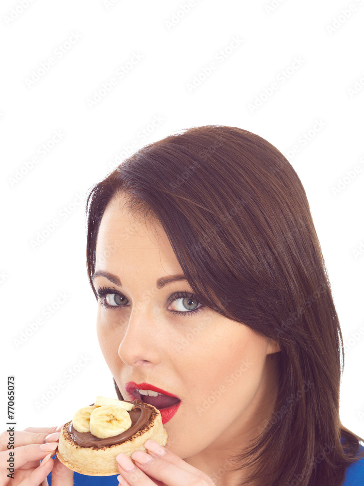 Young Woman Eating Crumpet with Chocolate Spread and Banana Young Woman Eating Crumpet with Chocolate Spread and Banana