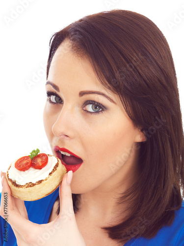 Young Woman Eating Toasted Crumpet with Cream Cheese and Tomato