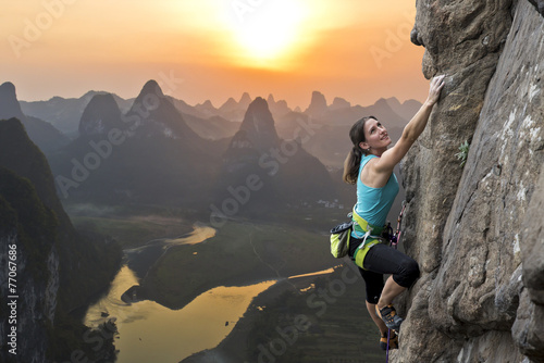 Photographie Femme grimpeur contre le coucher du soleil à la rivière Li