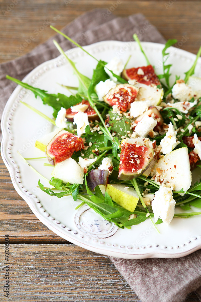 Delicious salad with arugula, slices of cheese and pears on a pl Delicious salad with arugula, slices of cheese and pears on a pl