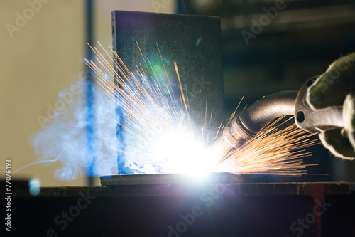 Closeup of welding metal with arc and torch