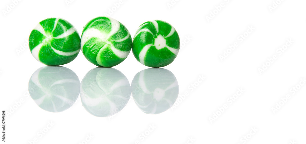 Green swirl peppermint candies over white background Green swirl peppermint candies over white background