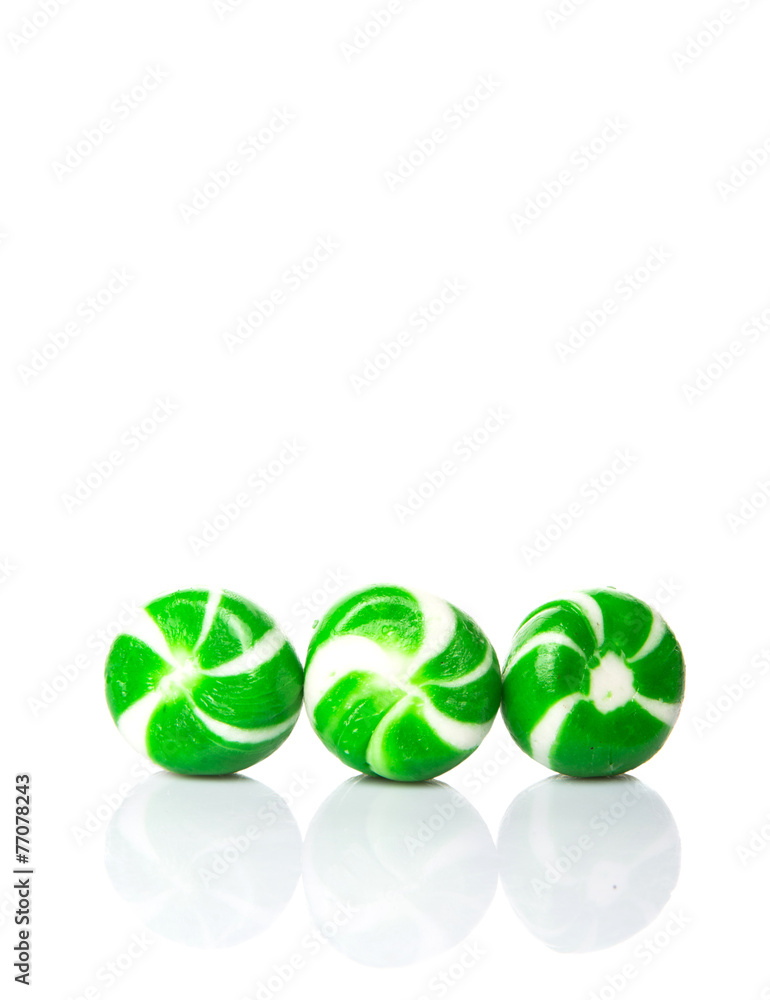 Green swirl peppermint candies over white background Green swirl peppermint candies over white background