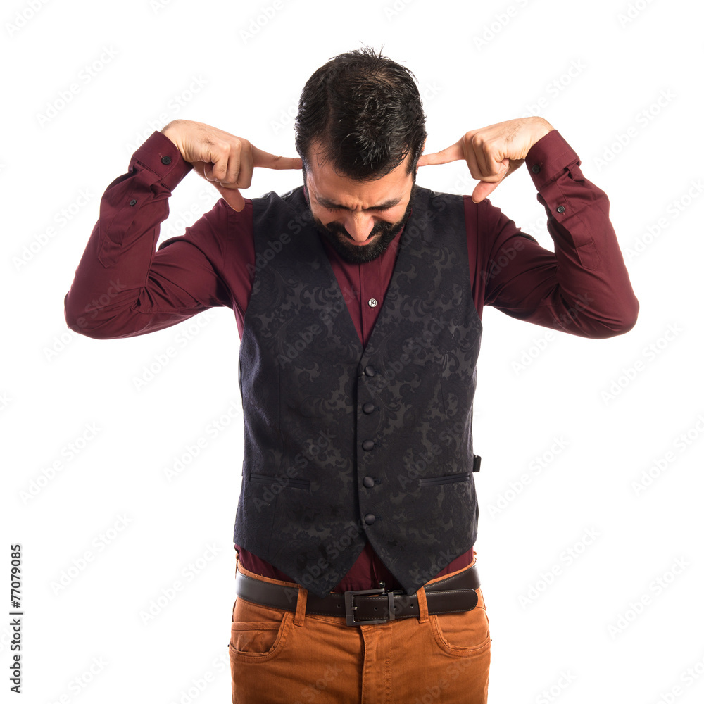 Man wearing waistcoat covering his ears Man wearing waistcoat covering his ears