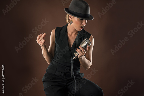 stylish woman in a hat with a retro microphone