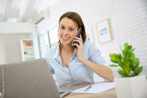 Woman in office talking on mobile phone