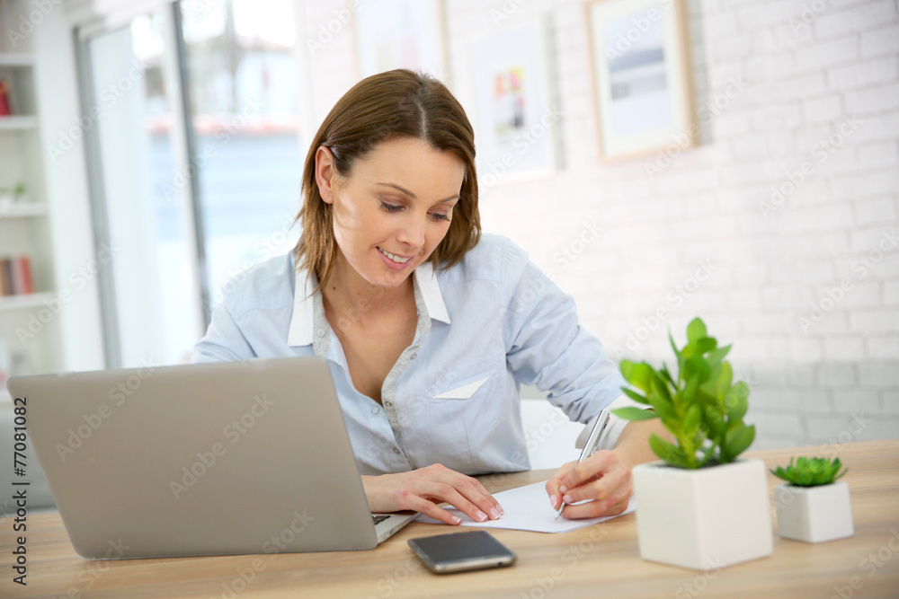 Woman in office writing on paper Woman in office writing on paper