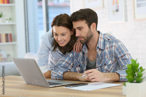 Couple at home websurfing on internet