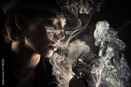Photography singer woman with retro microphone in smoke