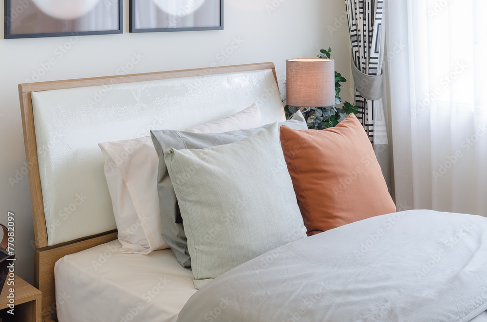 Obraz premium orange color pillow on white bed in bedroom