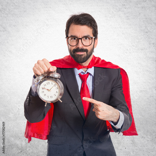 Businessman dressed like superhero holding a clock
