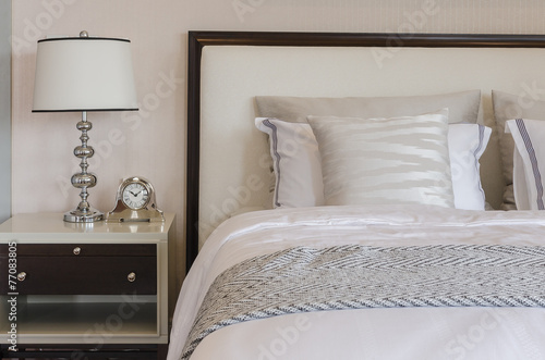 luxury bedroom with white classic lamp and clock on table