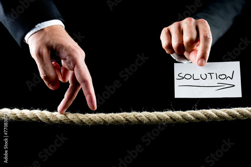 Foto Male hand walking on frayed rope towards solution