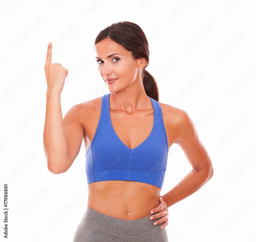 Brunette sporty female in shorts pointing up Brunette sporty female in shorts pointing up