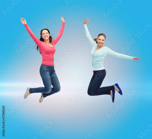 smiling young women jumping in air
