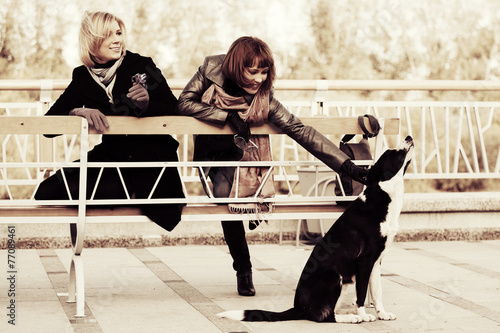 Two young fashion women and a dog