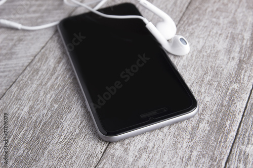 smartphone and headphones on the wooden table
