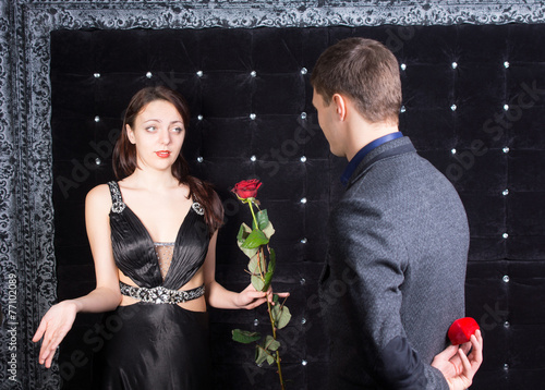 Young Man Offering a Flower to Unhappy Lady photo