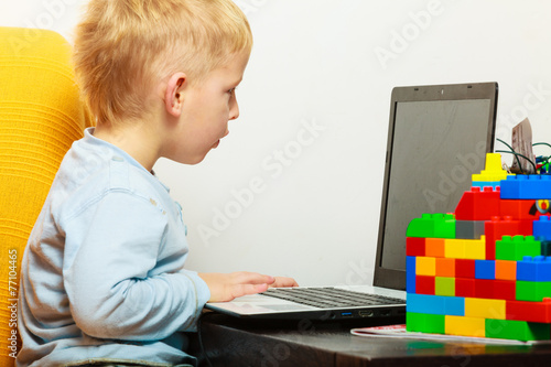 little boy using laptop pc computer at home