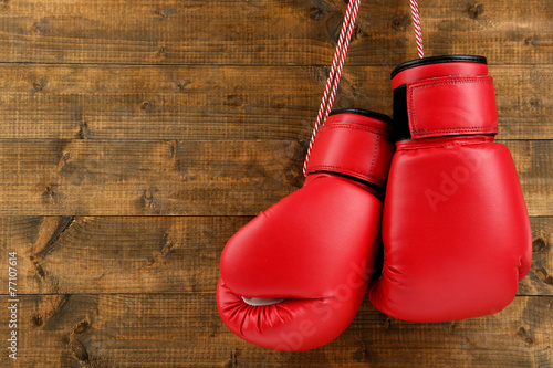 Pair of boxing gloves on wooden planks background © Africa Studio