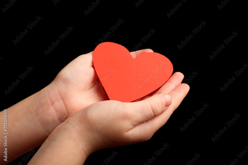 Heart in child hands on black background Heart in child hands on black background