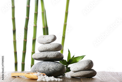Stack of spa stones with spoon of sea salt