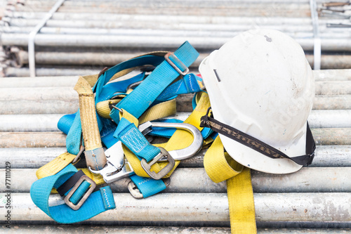 Fotografie Safety helmet and harness at a construction site