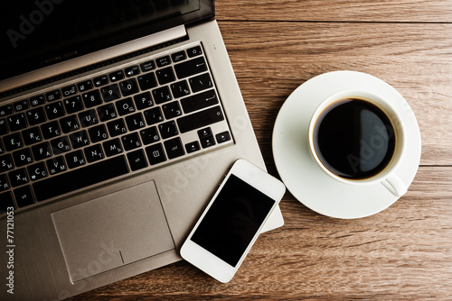 open laptop with phone and cup of coffee