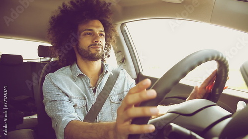 Handsome cool man starting to smile driving car