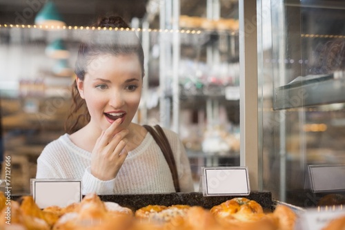 Pretty brunette looking at pastrys