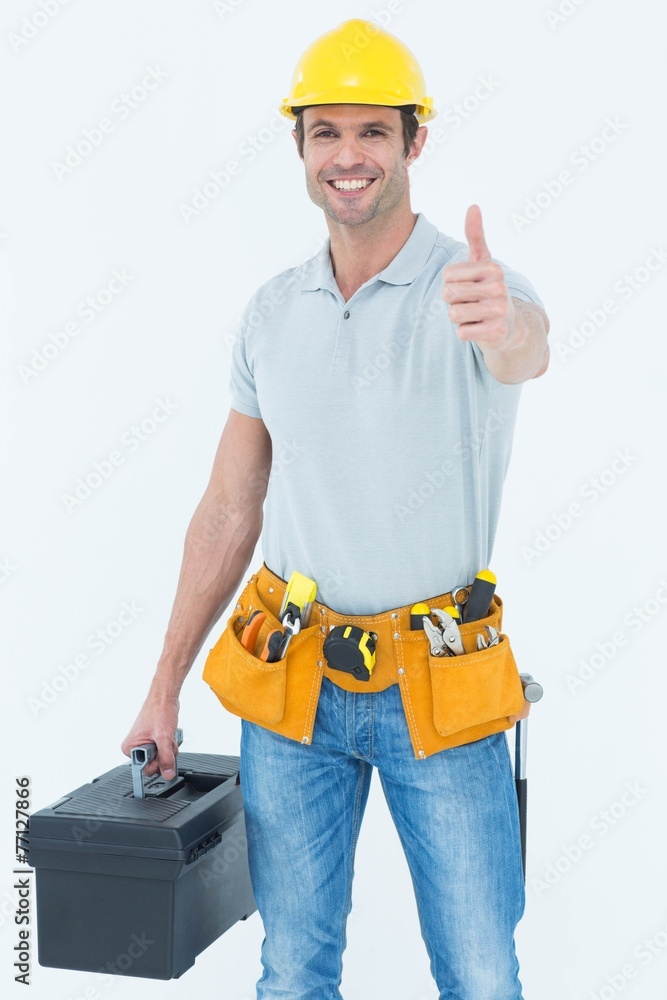 Handyman showing thumbs up while holding tool box Handyman showing thumbs up while holding tool box