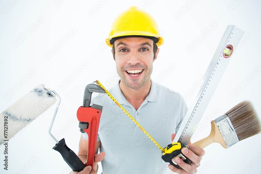 Portrait of happy worker holding various equipment Portrait of happy worker holding various equipment