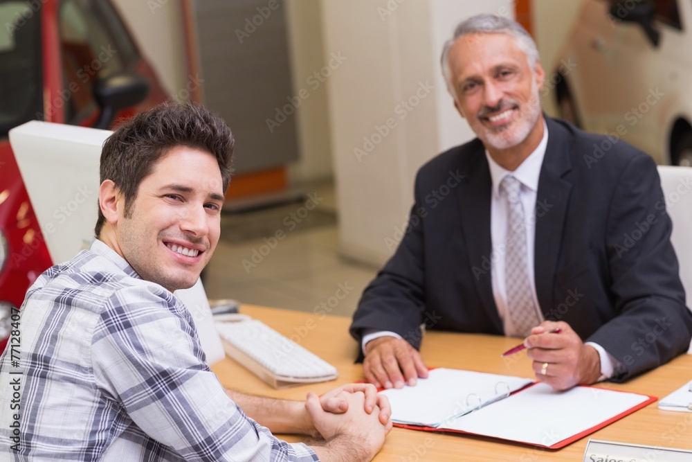 Smiling businessman and customer looking at camera Smiling businessman and customer looking at camera