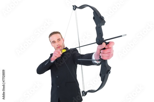Concentrated businessman shooting a bow and arrow