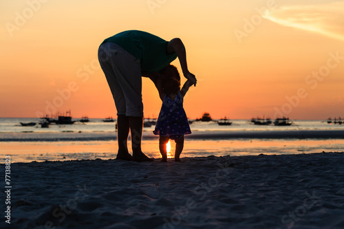 Silhouette of father and little daughter on sunset
