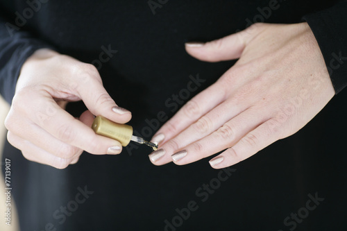 Frau lackiert sich die Fingern  gel