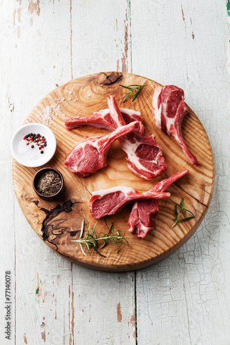 Raw fresh lamb ribs with salt, pepper and cumin on wooden cuttin