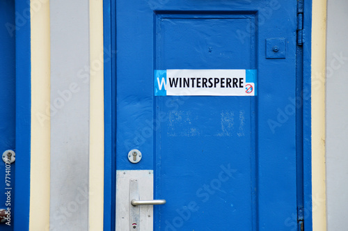 Blaue Eisentür mit Aufkleber Wintersperre