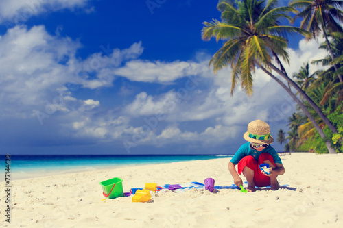 Fototapeta Naklejka Na Ścianę i Meble -  little boy building sand castle on beach
