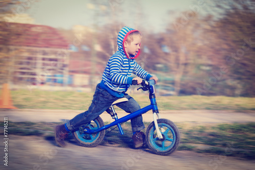 little boy riding runbike photo