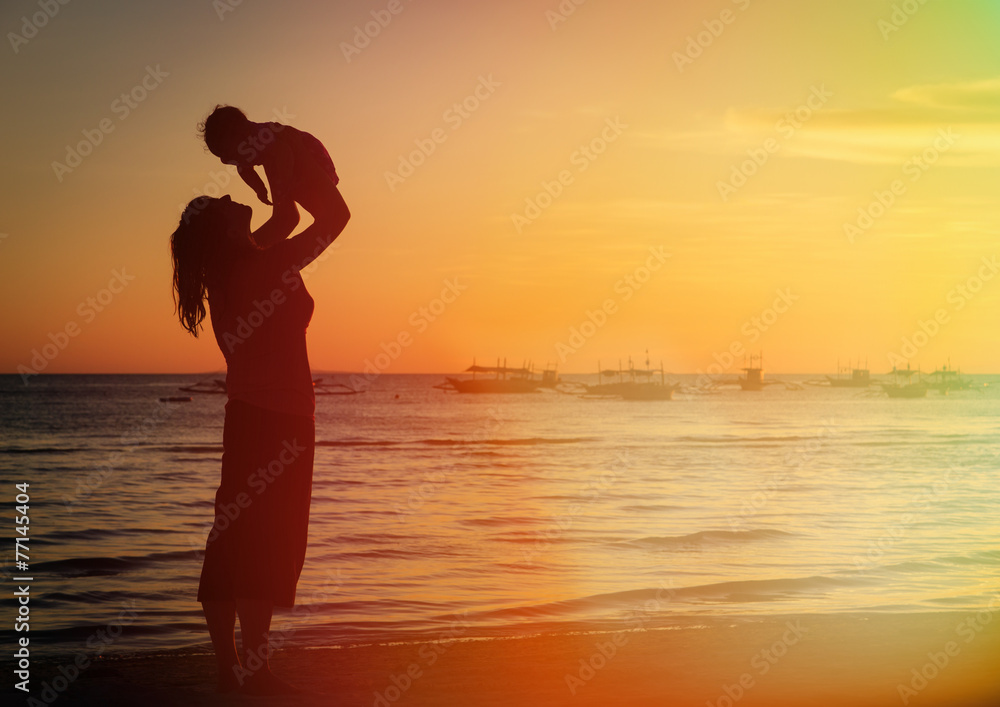 Fototapeta premium mother and daughter having fun at sunset beach